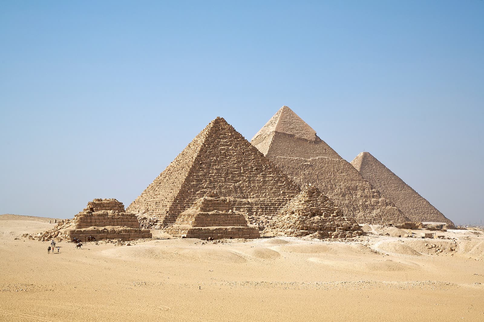 Les pyramides de Gizeh dans le sable, sous un ciel bleu